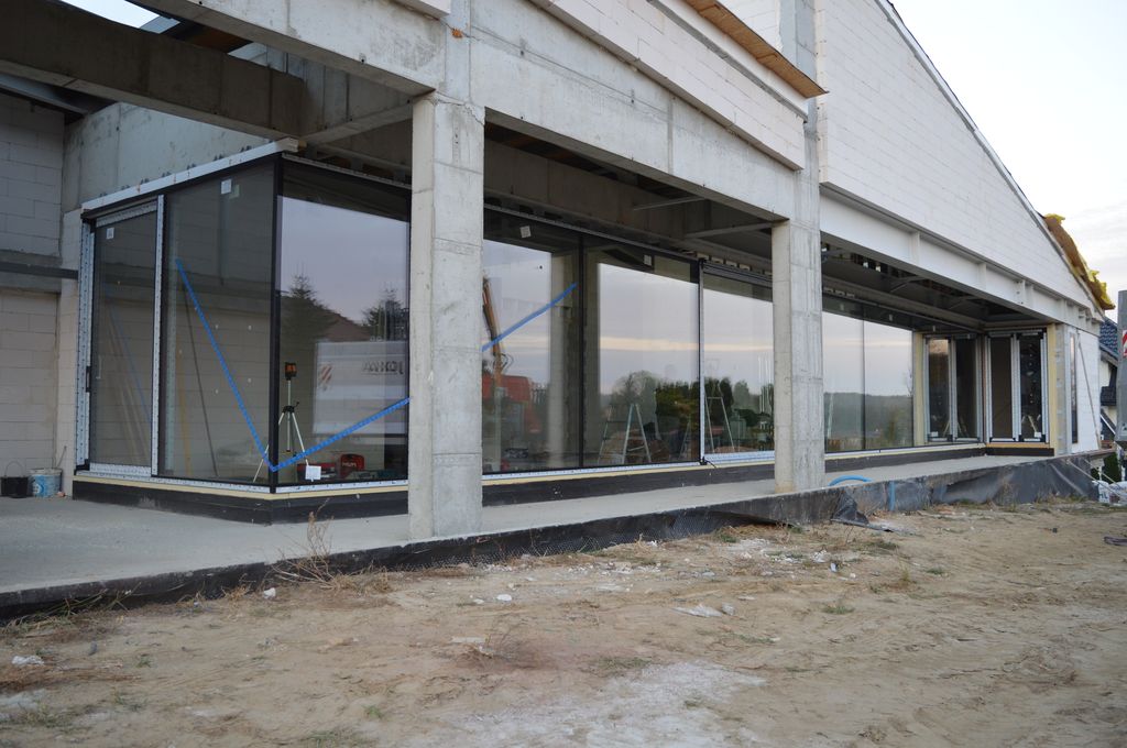 Zamontowana konstrukcja okienna o szerokości 25 metrów składająca się z drzwi balkonowych HST z glass cornerem oraz oszkleń stałych łączonych na styk szyba do szyby
