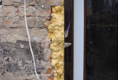 Błąd montażu okna pcv. Montaż w nieprzygotowanej ościeży. Ubytki muru wypełnione jedynie pianką montażową. Mostek termiczny.